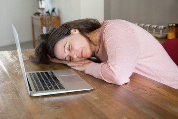 Tired freelance woman sleeping on table