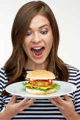 happy woman holding burger on white plate.