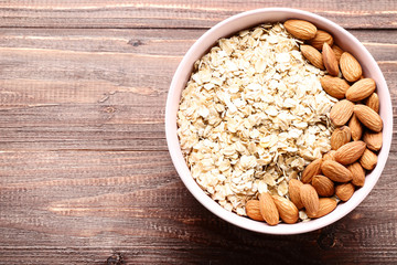 Oatmeal with almonds in bowl on brown wooden table