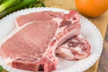 Ingredients for roasted pork chops and vegetables with avocado orange salsa