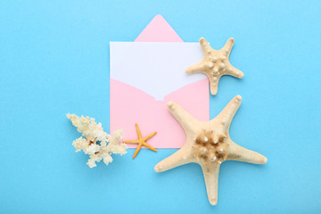 Fototapeta na wymiar Blank paper with envelope and starfishes on blue background