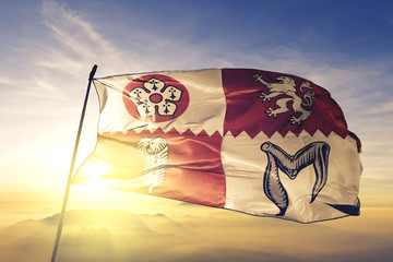 Leicestershire county of England flag waving on the top sunrise mist fog