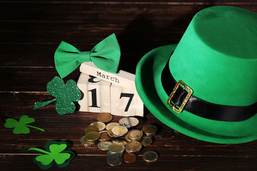 St. Patrick's Day. Green hat with clover leafs, wooden calendar and coins