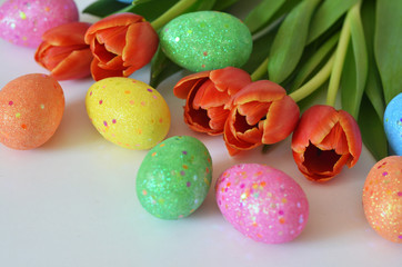Happy Easter. Congratulatory easter background. Easter eggs and flowers tulip on white background.