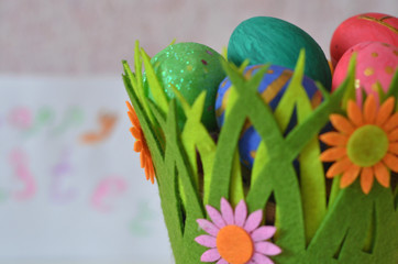 Happy Easter Day. Easter eggs concept. Closeup Colorful Easter eggs in nest and basket green crass on white wooden background.