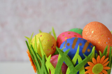 Happy Easter Day. Easter eggs concept. Closeup Colorful Easter eggs in nest and basket green crass on white wooden background.
