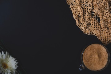 Flat lay with black background with coffee mug and donut with  lace