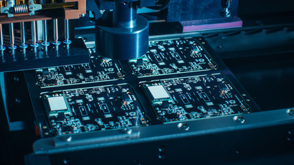 Macro Close-up Shot of Printed Circuit Board on a Factory Assembly Line with Automated Robotic Arm...