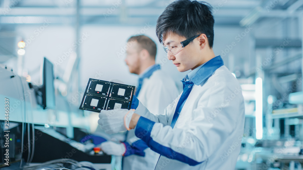 Wall mural high-tech factory: quality control engineer checks electronic printed circuit board it for damages. 