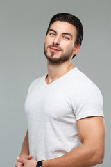 Attractive athletic man in a white shirt isolated on gray background.