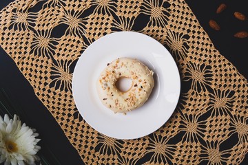 Flat lay with black background with coffee mug and donut with  lace