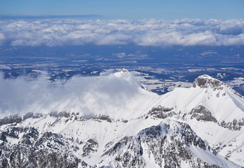 Fototapeta premium Clouds Sweeping Across Snow-Covered Peaks in the High Tatras, Slovakia