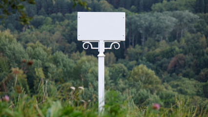 White blank sign on a forest background. Warning sign.