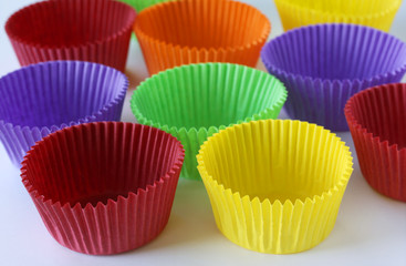 Colorful empty paper forms capsules for muffins and cupcakes on white background - baking dessert - close up on white background