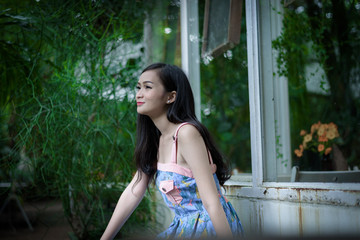 Naklejka premium Asian pretty girl has relaxing with happy and smiling at Little Tree Garden cafe, Nakhon Pathom province, Thailand in the morning.
