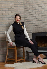 Fototapeta premium Blonde in a black vest and fireplace
