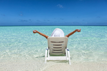 Fototapeta na wymiar woman relaxing on the beach, rear view