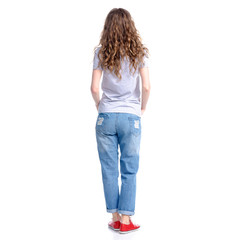 Woman in jeans standing looking on white background isolation, rear view