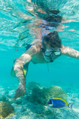Man snorkeling above a shallow reef.Underwater view.