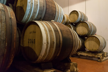 Wine barrels stacked in the old cellar of the winery. 