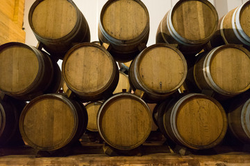 Wine barrels stacked in the old cellar of the winery. 