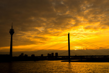 sunset behind bridge and tower