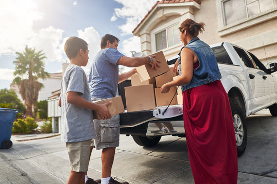 Hispanic Family Unloading Pickup Truck And Moving Into New House In Las Vegas