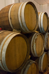 Wine barrels stacked in the old cellar of the winery. 