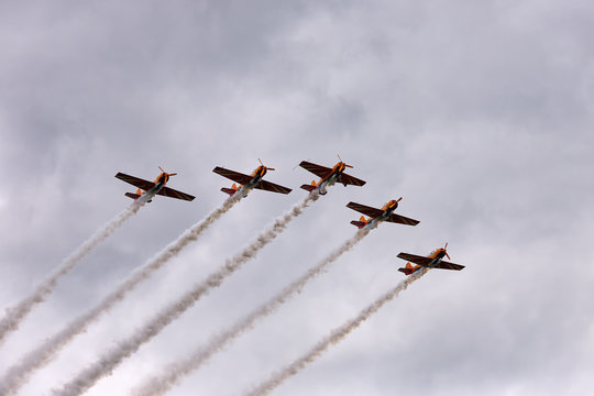 A group of aircraft performs acrobatic demonstration numbers on the air show
