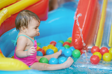 Fototapeta na wymiar Little baby girl in rubber pool