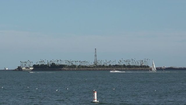 Boats passing by Freeman Island oil drilling rigs in Long Beach harbor