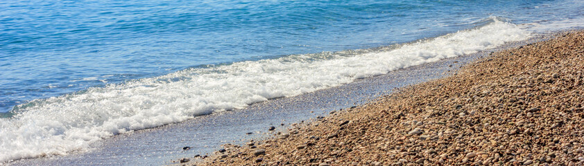 Mediterranean landscape in Antalya, Turkey. Blue sea, waves and pebble sandy beach