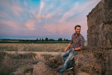 Happy man sitting on a pile of hay