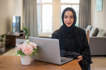 Young Arabic business woman wearing hijab with laptop at home