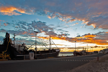 Fishing boats in harbour at sunset