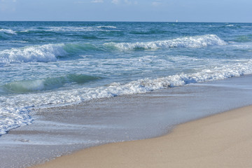 Fototapeta na wymiar Sea, Blue waves with white foam, under the blue sky.