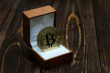 The best gift bitcoin coin on a wooden background. The concept of investing in cryptocurrency