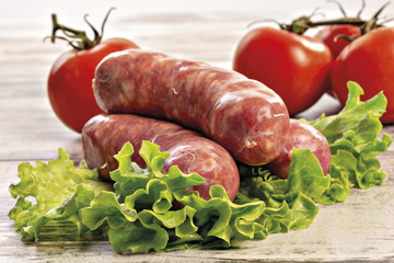salsicce crude tre con insalata e pomodori fronte altra vista