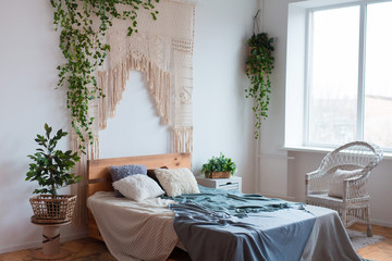 Cozy interior design of modern studio apartment in Scandinavian style. A spacious huge room in light colors with wooden bed and stylish expensive luxury furniture.