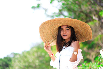 Asian woman putting on big wide hat