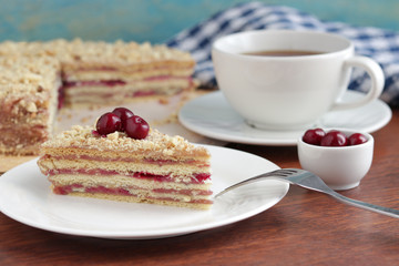 homemade cake with cherry berries on white plate cup of tea on the table selective focus