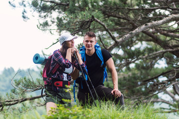 Beautiful young couple hiking together in the woods