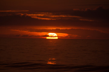 Sun behind clouds on a fired sky 1