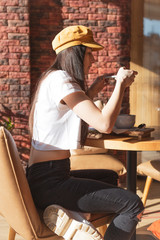 Stylish woman picks up a breakfast in a morning cafe on a smartphone for an instagram. Tasty morning breakfast - granola