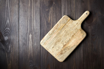 Fototapeta premium Cutting board on brown wooden table. Top view