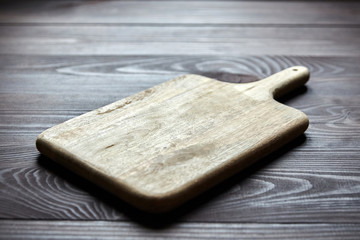 Cutting board from pine wood is on brown table