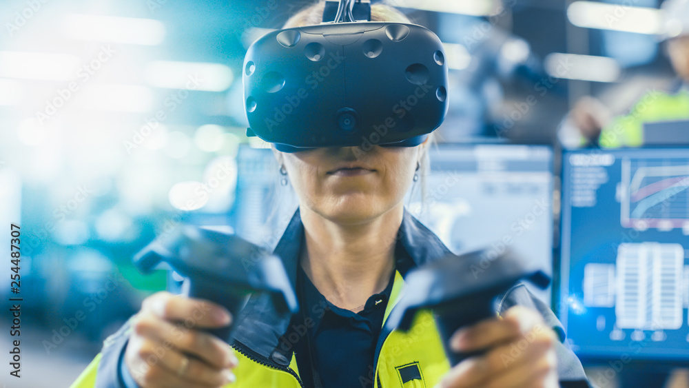 Fototapete Portrait Female Mechanical Engineer Wearing Virtual Reality Headset and Using Controllers, She Uses VR technology for Industrial Design, Development and Prototyping in CAD Software. 