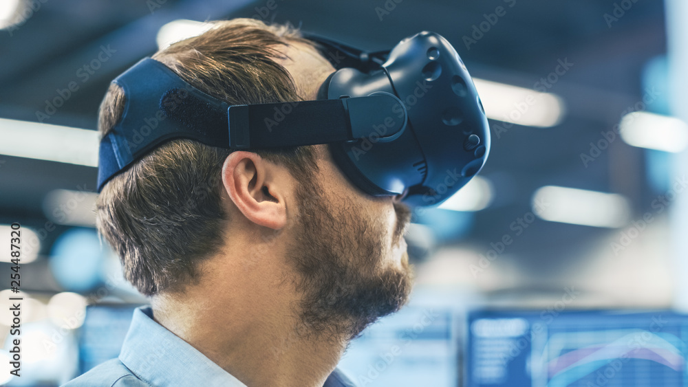 Poster portrait shot of the industrial engineer wearing virtual reality headset and gesturing with controll