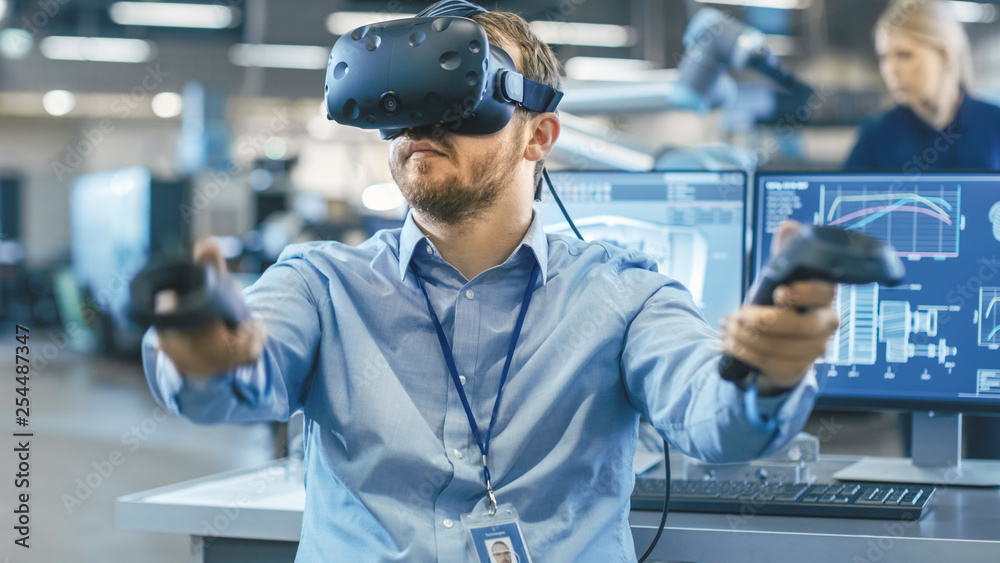 Poster portrait shot of the industrial engineer wearing virtual reality headset and using controllers, read