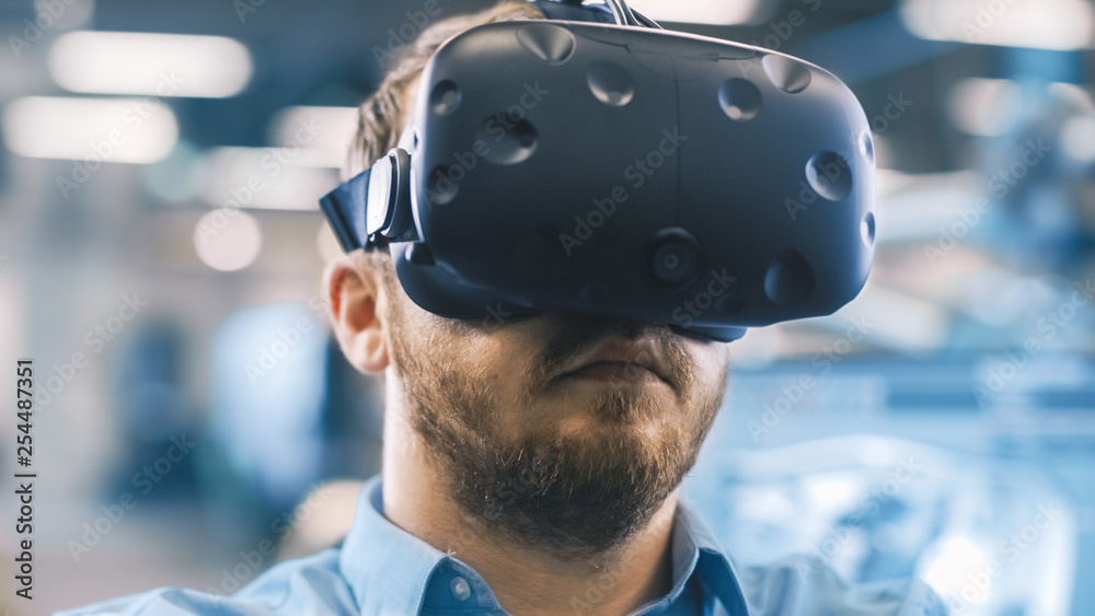 Poster portrait shot of the industrial engineer wearing virtual reality headset and gesturing with controll